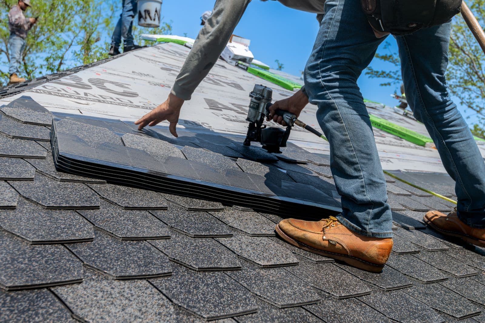 Roofer measuring and installing tiles on a residential roof