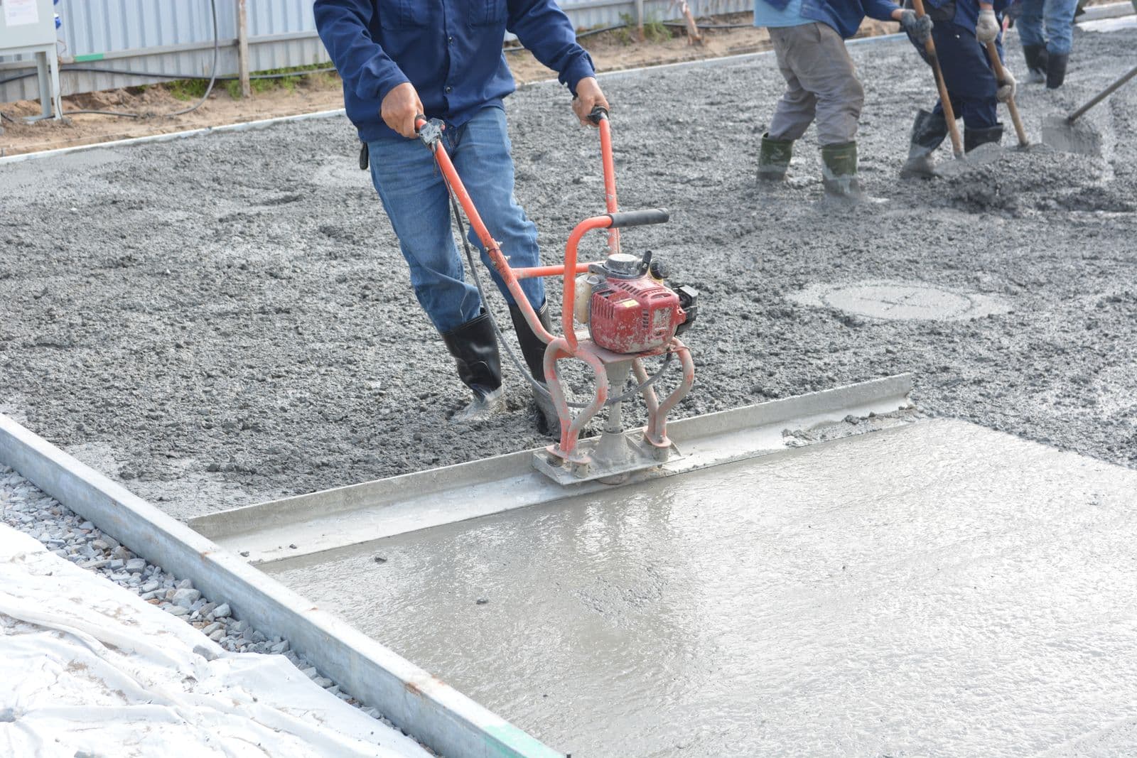 Concrete finisher smoothing a freshly poured slab